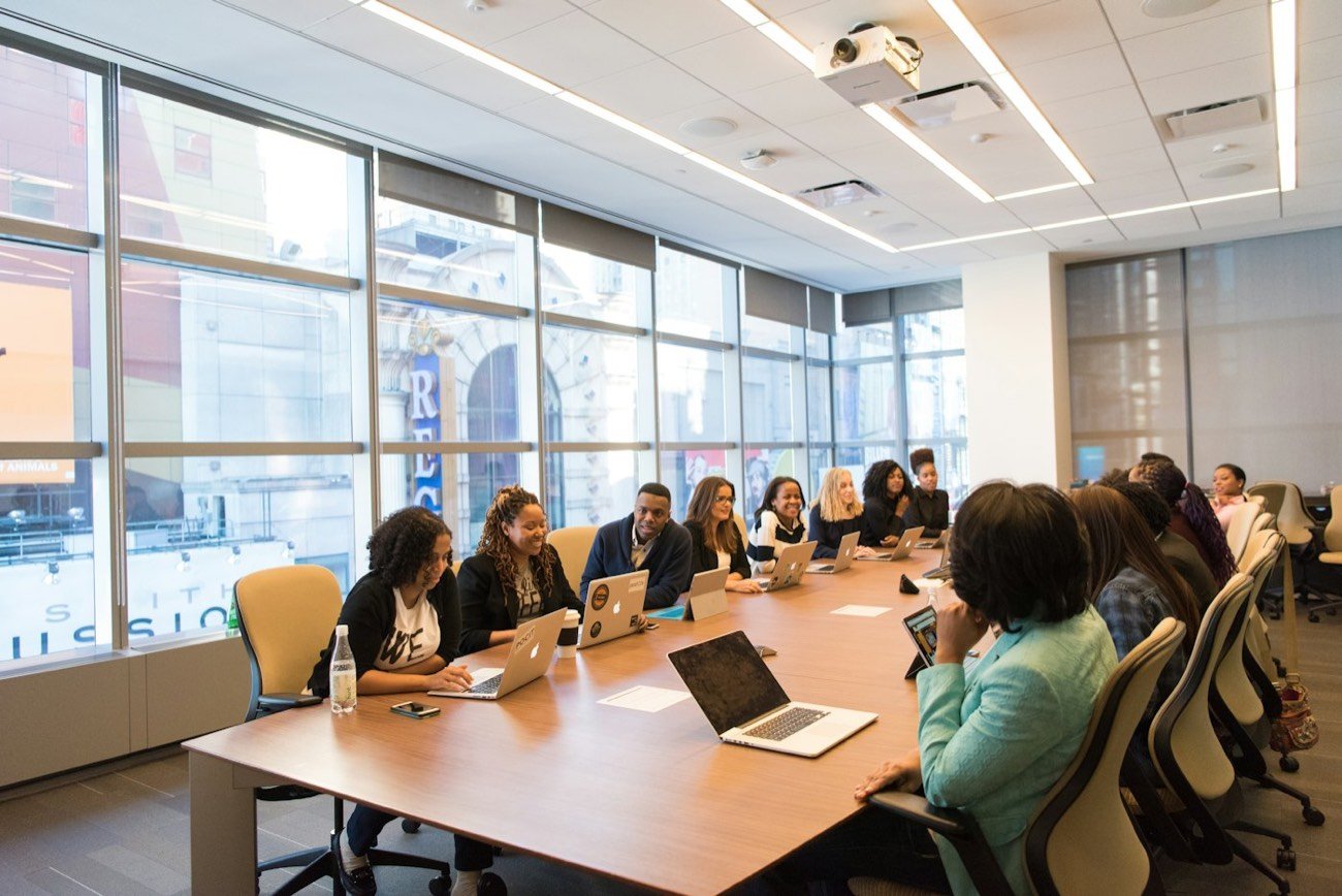A team meeting around a table with laptops